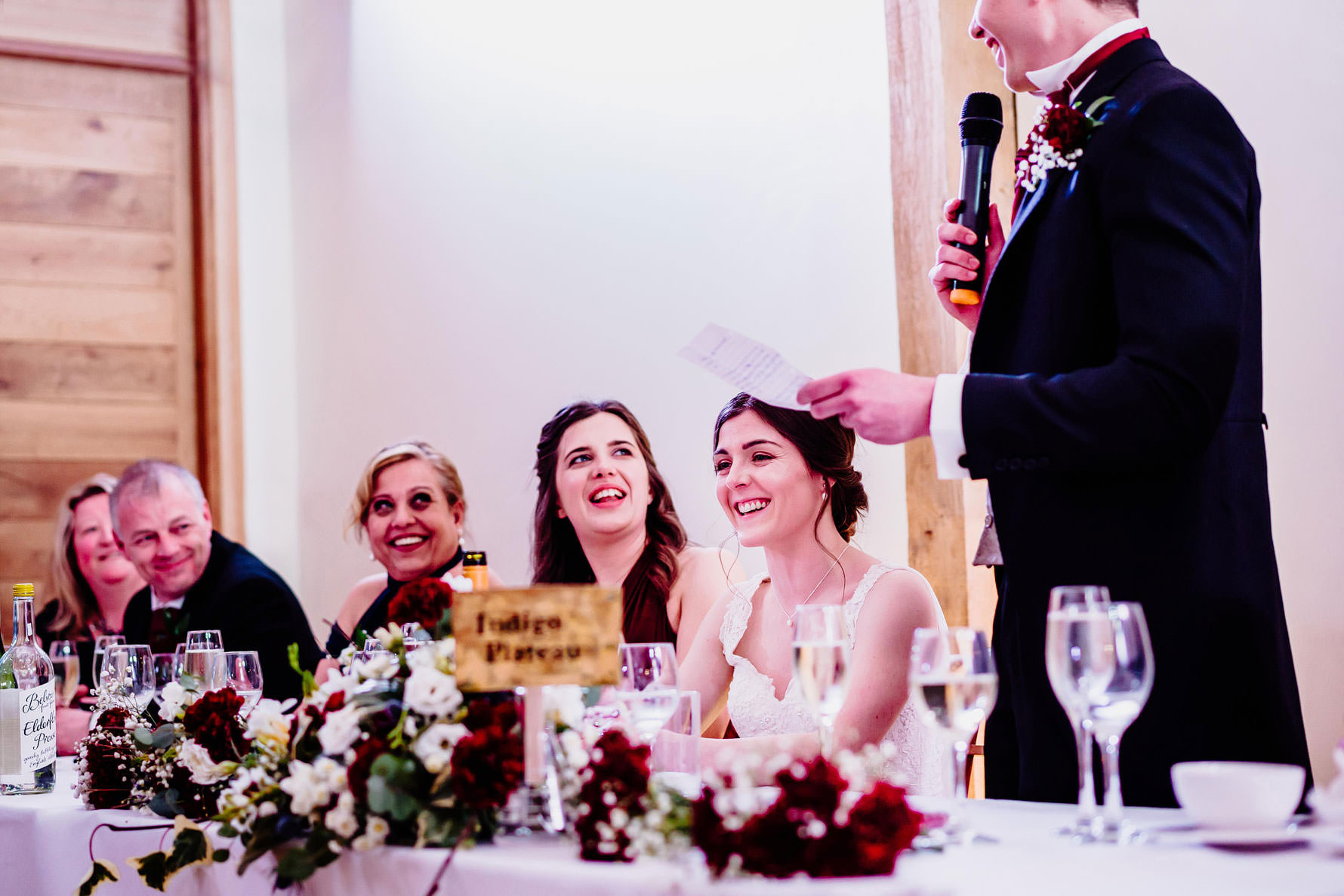 a bride laughs durning wedding speeches