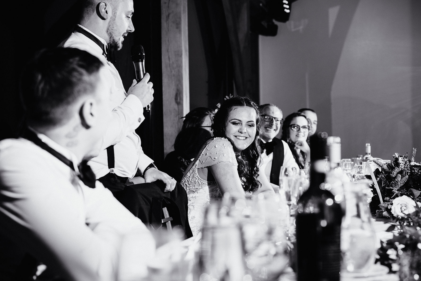 a bride smiles during wedding speeches